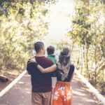 A family enjoying a leisurely walk on a sunny park trail, showcasing togetherness and love.